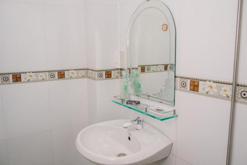 a white bathroom with a sink and a mirror at HIEP HOA HOTEL in Chau Doc