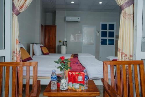 a bedroom with a bed with a table and two chairs at HIEP HOA HOTEL in Chau Doc