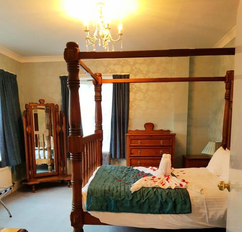 a bedroom with a four poster bed and a chandelier at The Chetwynde Hotel in Barrow in Furness