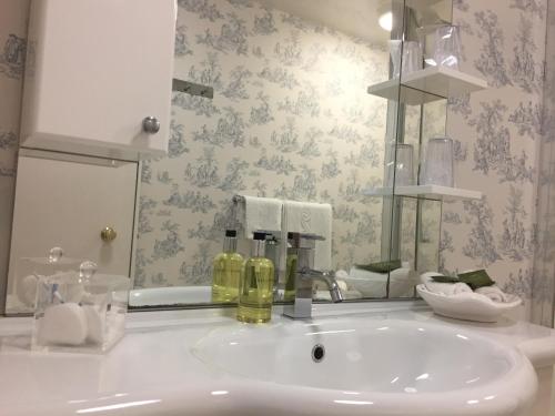 a bathroom with a white sink and a mirror at The Chetwynde Hotel in Barrow in Furness