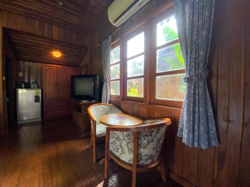 a room with a table and chairs and a television at Yuwadee Resort in Chalong