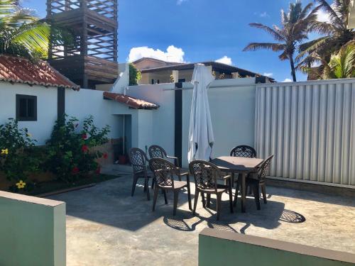 a patio with a table and chairs and an umbrella at Tabatinga Beach Hotel in Nísia Floresta