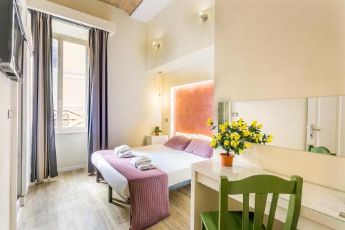 een hotelkamer met een bed, een bureau en een tafel bij AmoRoma Suite in Rome