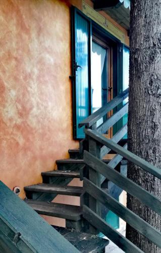 a wooden staircase next to a building with a tree at Hotel La Valle dell'Aquila in LʼAquila