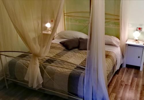 a bedroom with a bed with a canopy at Hotel La Valle dell'Aquila in LʼAquila