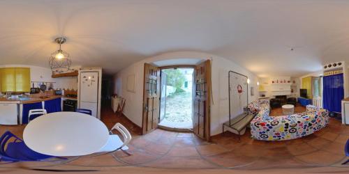a living room with a table and a kitchen at Molino de Simón in Benaoján