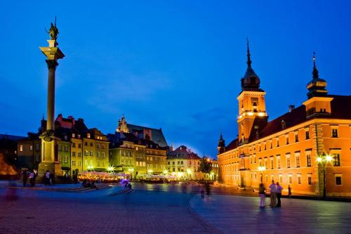 a group of buildings in a city at night at Castle Inn in Warsaw