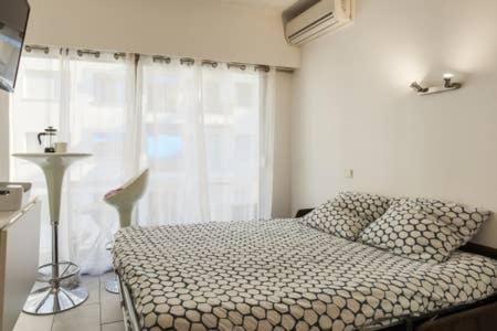 una camera con un letto e una grande finestra di Studio carré d'or situé à 50 m de la plage a Nizza