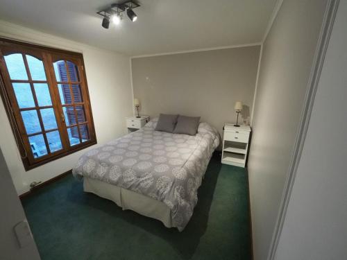 a small bedroom with a bed and a window at Santa Lucia in Ushuaia