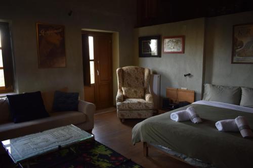 a bedroom with a bed and a couch and a chair at Great Mantineia in Levidhion