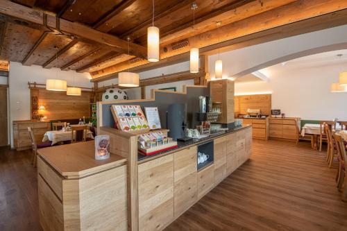 a restaurant with a counter in a room with tables at Landhotel Häuserl im Wald in Gröbming