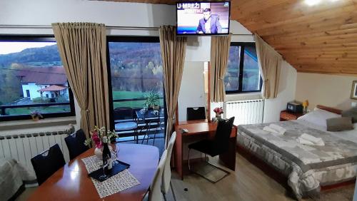 1 dormitorio con 1 cama, TV y mesa en Vuković House, en Selište Drežničko