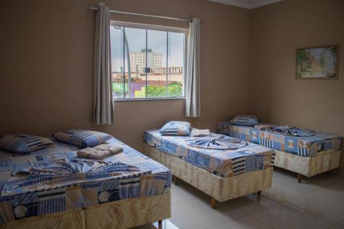 アパレシーダにあるHotel Santo Afonsoの窓のある部屋にベッドが3つある