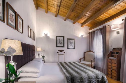 a bedroom with a bed and a chair at Molino de Alcuneza Relais & Châteaux in Sigüenza