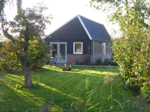 a house in a yard with a tree at Beemster Oase in De Beemster