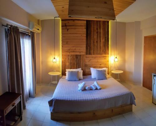 um quarto com uma cama grande e duas mesas em Anemos Hotel em Polykhrono