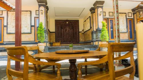 a wooden table and chairs in a room at Cakra House in Denpasar