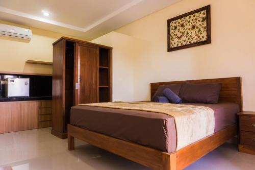 a bedroom with a large bed and a kitchen at Cakra House in Denpasar