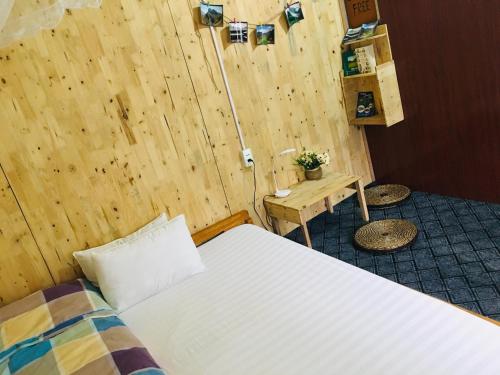a bedroom with a bed and a wooden wall at Green Hill Hostel & Tour in Ha Giang