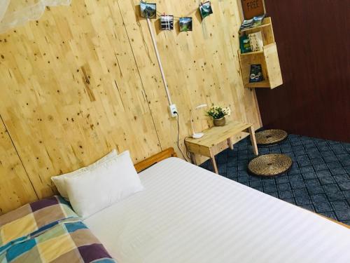 una camera con letto e parete in legno di Green Hill Hostel & Tour a Ha Giang