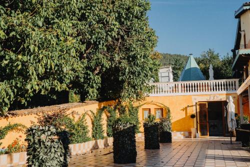 a yellow house with a fence and a tree at Hotel La Valle dell'Aquila in LʼAquila