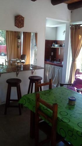 a kitchen with a table and stools in a room at La casita de Pablo in Santa Teresita
