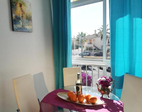 einen Tisch mit einem Obstteller und einer Flasche Wein in der Unterkunft Lovely home La Mata pool&beach in Torrevieja