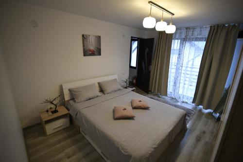 a bedroom with a bed with two pillows on it at Upstairs Residence in Târgu Jiu