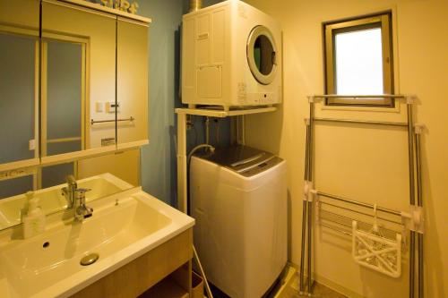 un bagno con lavandino e lavatrice di #3LDK一軒家 #長期滞在可能 #海まで4分-- Starry Sky Resort Okinawa -- a Onna