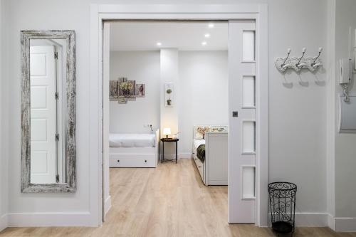 Habitación blanca con espejo y dormitorio en Bilbao Centro con opción de Parking, en Bilbao