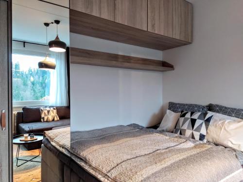 a bedroom with a bed and a couch at Stylový apartmán přímo u lanovky, vlastní garážové stání in Janske Lazne