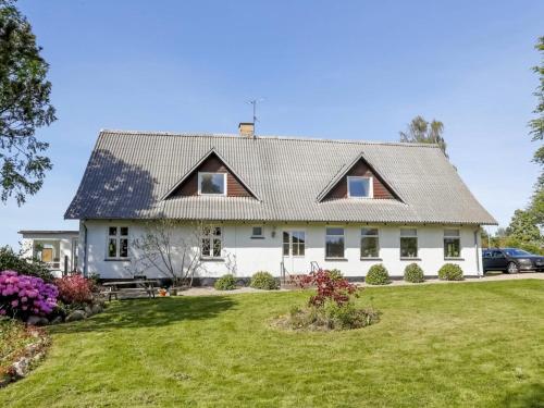 une grande maison blanche avec une grande cour dans l'établissement Den Gamle Apotekergaard, à Høng
