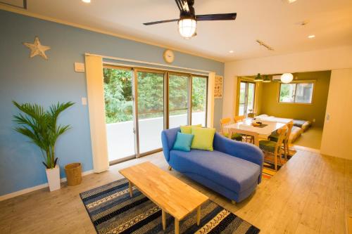 sala de estar con sofá azul y mesa en #3LDK一軒家 #長期滞在可能 #海まで4分-- Starry Sky Resort Okinawa -- en Onna