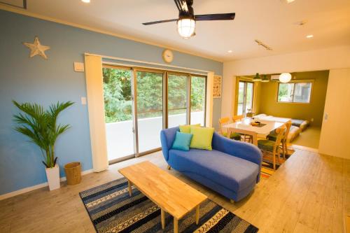 恩納村にある#3LDK一軒家 #長期滞在可能 #海まで4分-- Starry Sky Resort Okinawa --のリビングルーム(青いソファ、テーブル付)