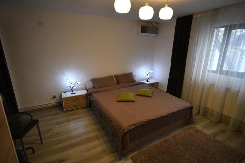 a bedroom with a bed with two green pillows on it at Upstairs Residence in Târgu Jiu