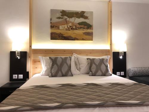 a bedroom with a large bed with two lamps at Acrotel Sofia's Guest House in Sidherás