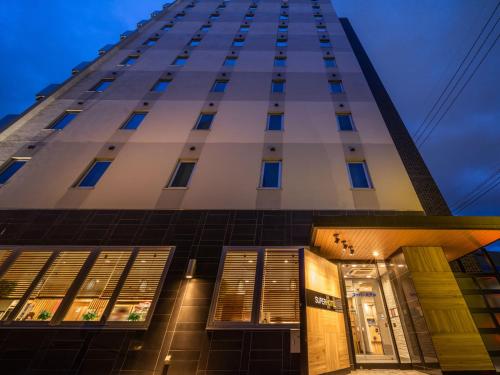 a tall building at night with its lights on at SUPERHOTEL Matsumoto Oshiroguchi in Matsumoto