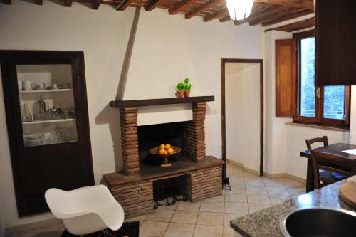 a living room with a fireplace with a bowl of fruit at Casa Messi in Pitigliano