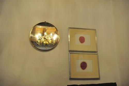 a room with two pictures and a mirror on a wall at Casa Messi in Pitigliano