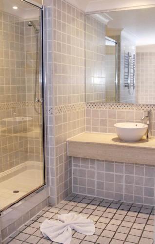 a bathroom with a shower and a sink and a mirror at The Priest House On The River in Castle Donington
