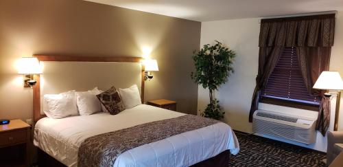 Postel nebo postele na pokoji v ubytování Stagecoach Inn & Suites