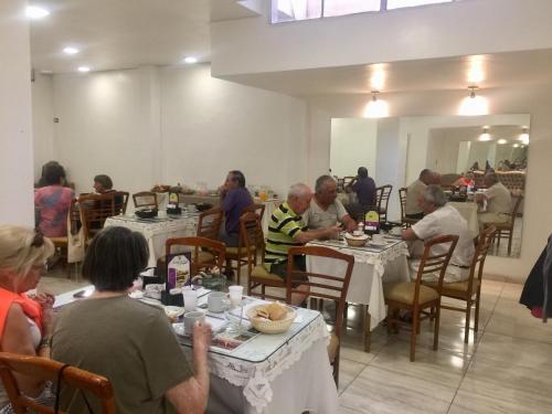 un grupo de personas sentadas en mesas en un restaurante en Hotel Plaza San Juan en San Juan