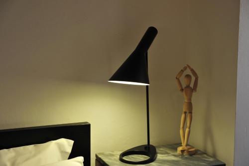 a lamp on a night stand next to a bed at Casa Messi in Pitigliano