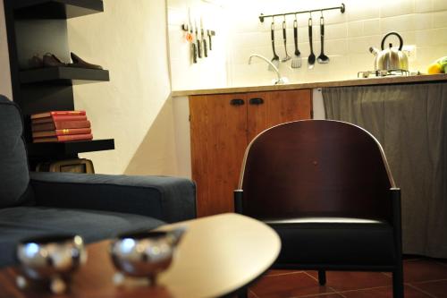 a living room with a table and a chair and a kitchen at Casa Messi in Pitigliano