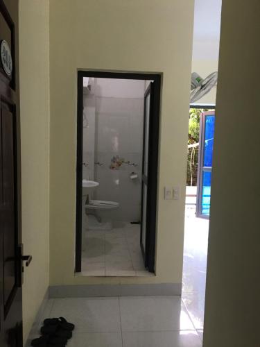La salle de bains est pourvue d'un miroir, d'un lavabo et de toilettes. dans l'établissement Duc Thang Guest House (Nhà Nghỉ Đức Thắng), à Diện Biên Phủ