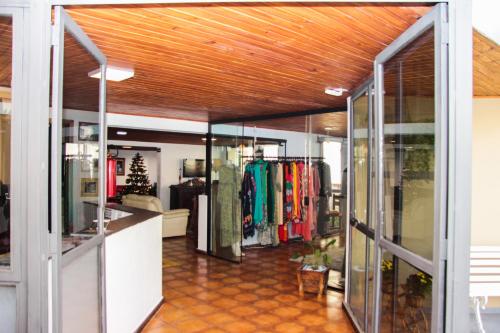 Una tienda de ropa con puertas de cristal y techo de madera. en Hotel Salvador, en Poços de Caldas