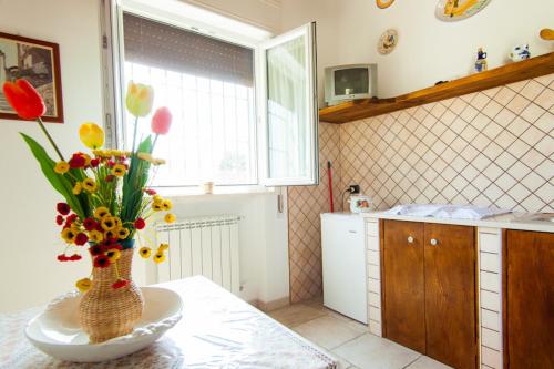 un vase de fleurs sur une table dans une cuisine dans l'établissement Villa Marida, à Gioia del Colle