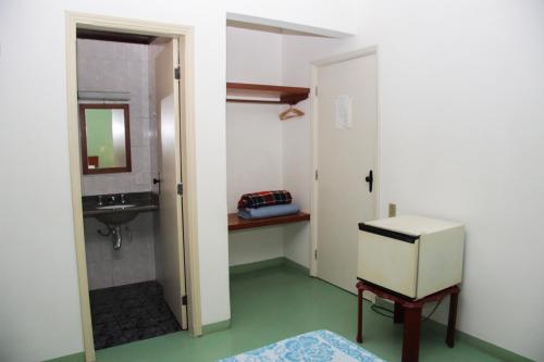 un baño con lavabo y espejo en Hotel Salvador, en Poços de Caldas