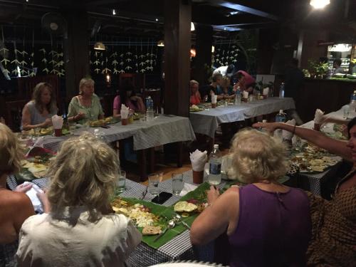 a group of people sitting at a table eating food at The Ocean Park Beach Resort in Kovalam