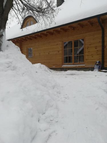 a pile of snow in front of a log cabin at Fajna Chatka in Ustrzyki Dolne